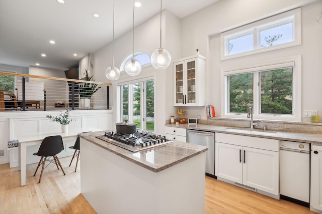 kitchen featuring appliances with stainless steel finishes, a wealth of natural light, light hardwood / wood-style floors, and sink