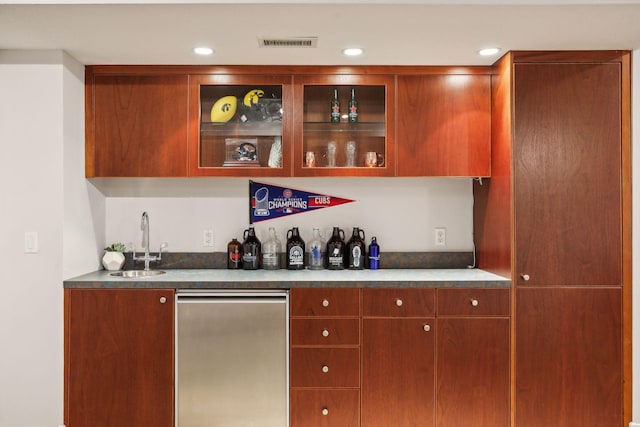 bar featuring stainless steel refrigerator and sink