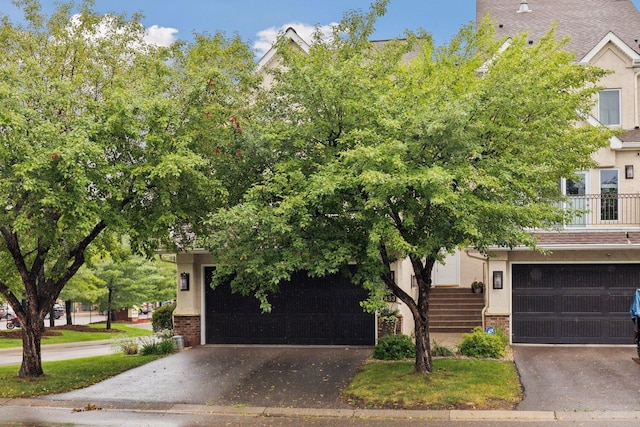 view of property hidden behind natural elements featuring a garage