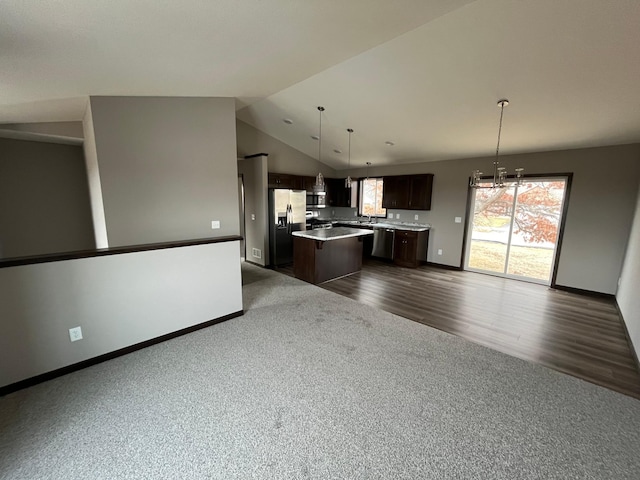 interior space featuring an inviting chandelier, dark brown cabinets, hanging light fixtures, a center island, and dark hardwood / wood-style flooring