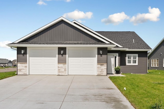 view of front of house with driveway, an attached garage, a front lawn, and a shingled roof