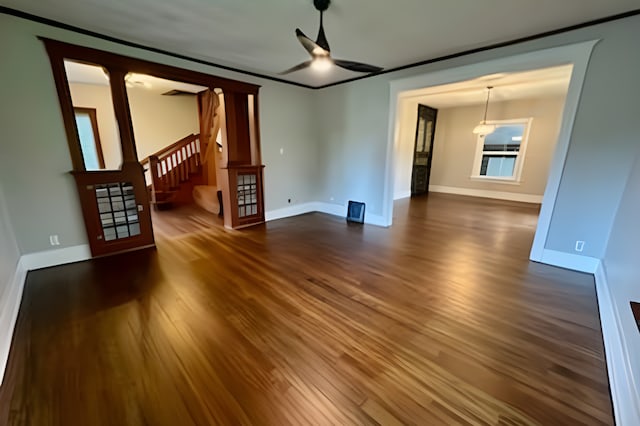 unfurnished living room featuring ceiling fan and dark hardwood / wood-style flooring