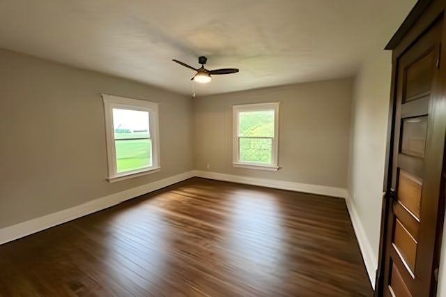 spare room featuring dark wood-type flooring and ceiling fan