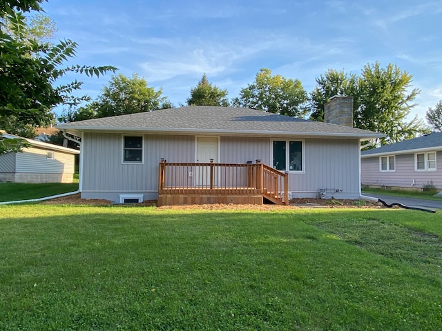 rear view of house with a wooden deck and a lawn