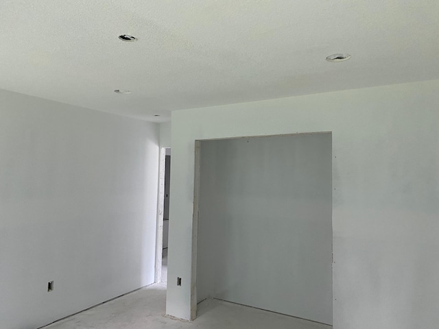 unfurnished room with a textured ceiling