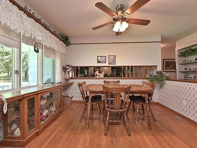 dining room featuring a textured ceiling, ceiling fan, and hardwood / wood-style floors