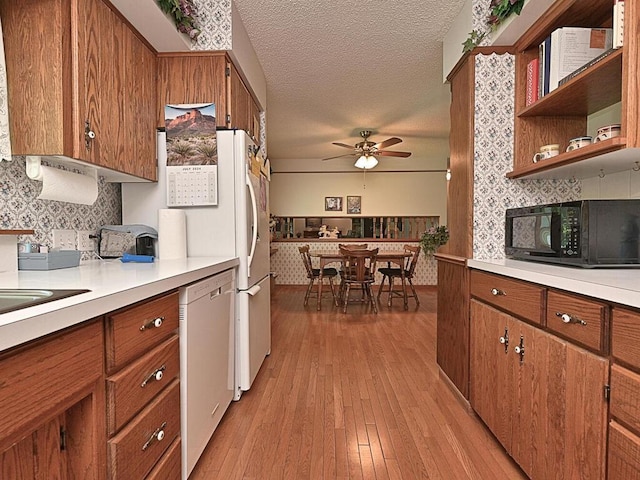 20761 Moose Point Rd, Grand Rapids, MN 55744 - kitchen featuring dishwasher, brown cabinetry, ceiling fan, and black microwave