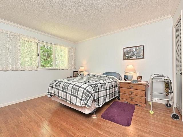 bedroom featuring wood-type flooring, crown molding, and a textured ceiling