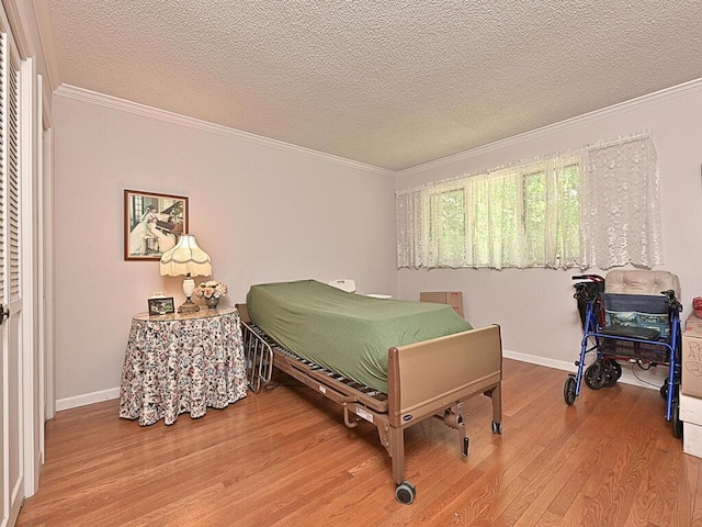 bedroom with ornamental molding, a textured ceiling, and hardwood / wood-style flooring