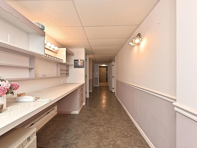 interior space with dark tile patterned flooring and a drop ceiling