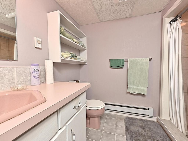 bathroom featuring toilet, tile patterned floors, vanity, a paneled ceiling, and baseboard heating