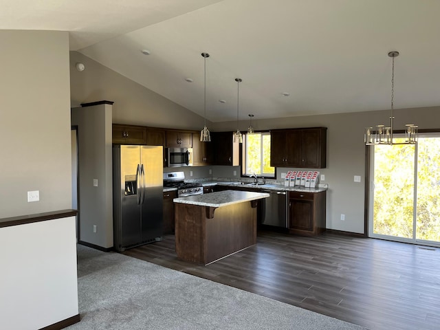 kitchen with hanging light fixtures, a kitchen island, stainless steel appliances, dark hardwood / wood-style floors, and a kitchen bar