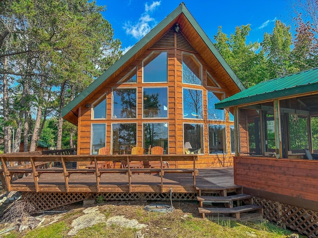 back of house featuring a sunroom and a deck