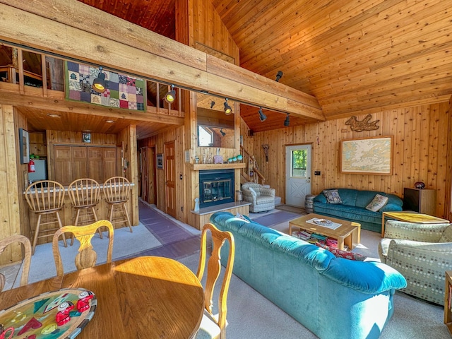 carpeted living room featuring wood ceiling, high vaulted ceiling, and wooden walls