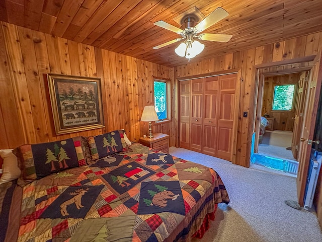 carpeted bedroom with wood ceiling, ceiling fan, and a closet