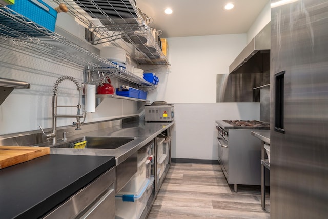 kitchen featuring sink, high quality appliances, and light wood-type flooring