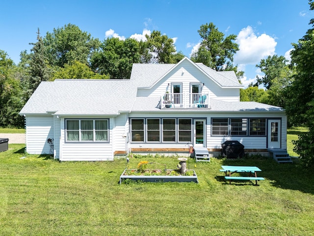 back of house with a lawn and a balcony