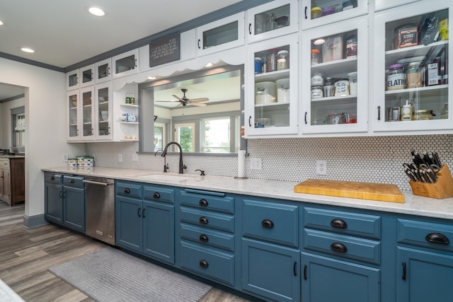 kitchen with blue cabinetry, dishwasher, light stone counters, sink, and white cabinetry