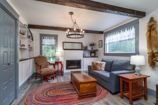 living room featuring beamed ceiling, a notable chandelier, and wood-type flooring