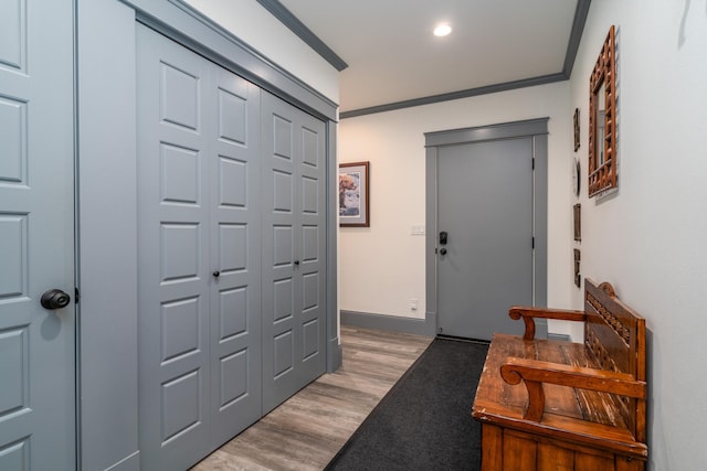 foyer entrance with ornamental molding and light hardwood / wood-style flooring