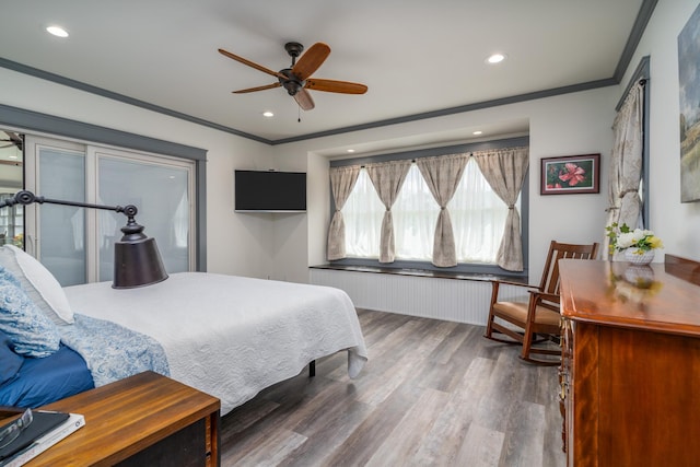 bedroom featuring ornamental molding, hardwood / wood-style flooring, and ceiling fan