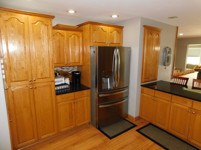 kitchen with decorative backsplash, stainless steel fridge, and light hardwood / wood-style floors