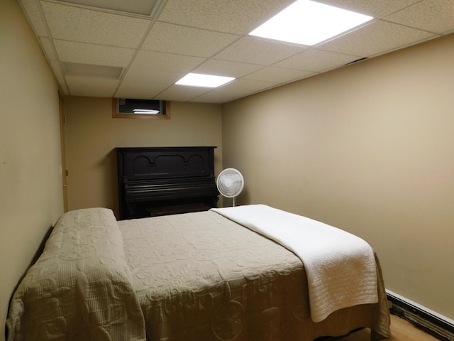 bedroom with a paneled ceiling and hardwood / wood-style flooring