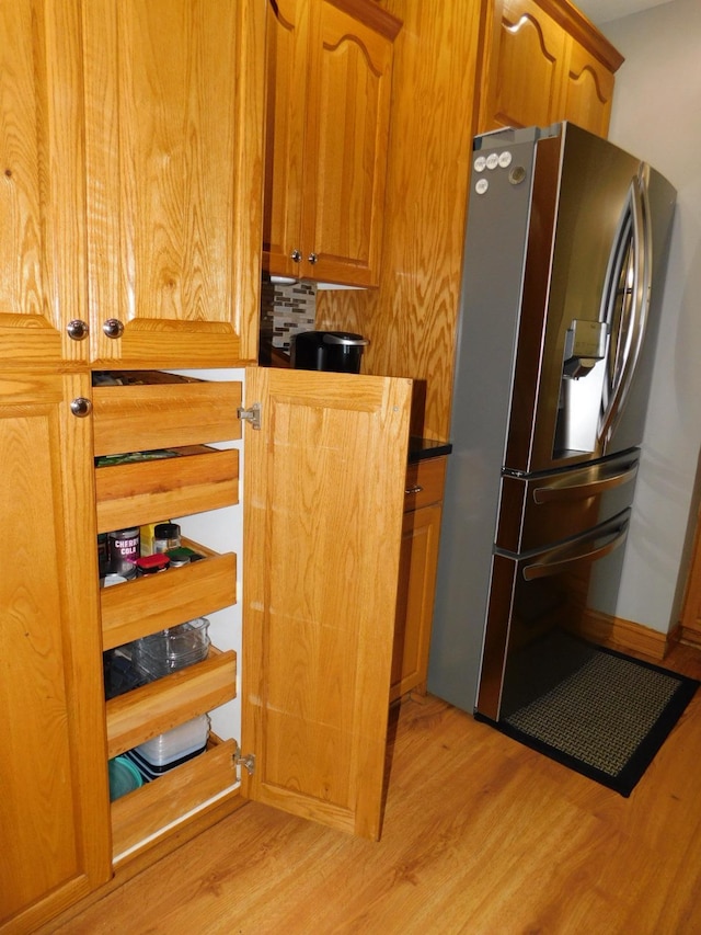 interior space with stainless steel fridge and light hardwood / wood-style floors