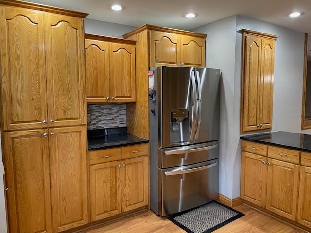 675 10th St, Granite Falls, MN 56241 - kitchen with stainless steel refrigerator with ice dispenser, tasteful backsplash, light wood-type flooring, dark countertops, and recessed lighting