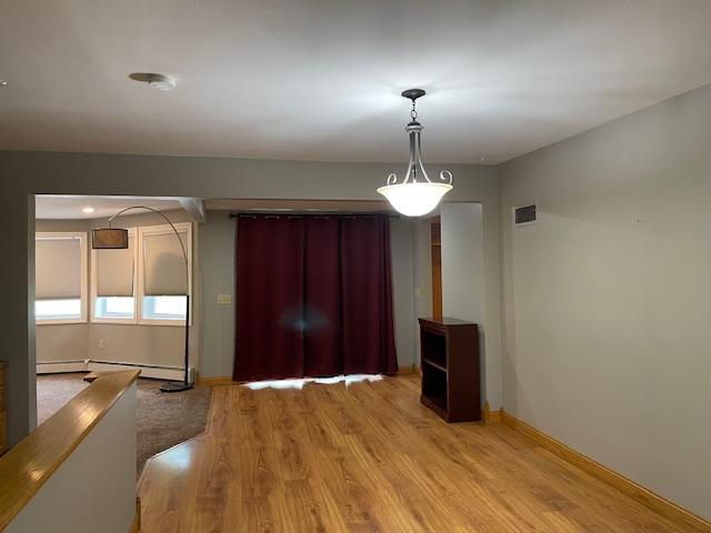 675 10th St, Granite Falls, MN 56241 - unfurnished dining area featuring light wood finished floors and baseboard heating