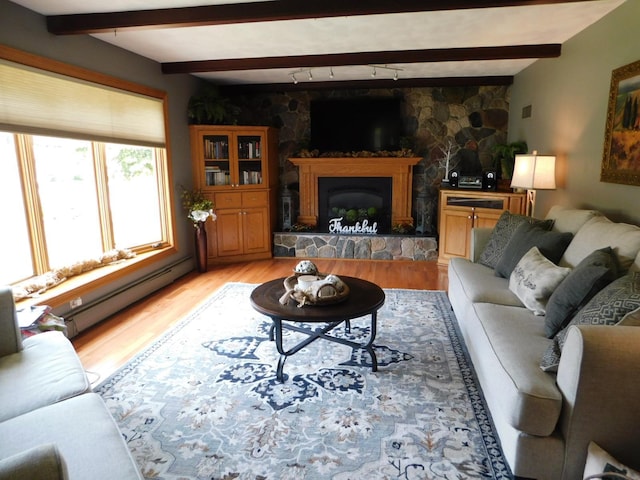 675 10th St, Granite Falls, MN 56241 - living room featuring a baseboard radiator, light wood-style flooring, beam ceiling, a fireplace, and rail lighting