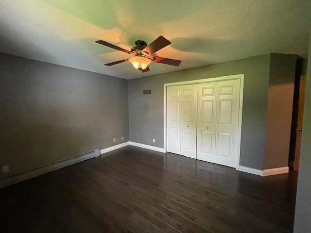 675 10th St, Granite Falls, MN 56241 - unfurnished bedroom with dark wood-type flooring, a closet, and a ceiling fan