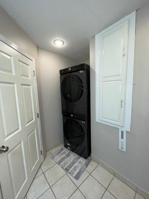 675 10th St, Granite Falls, MN 56241 - laundry area with estacked washer and dryer and light tile patterned flooring