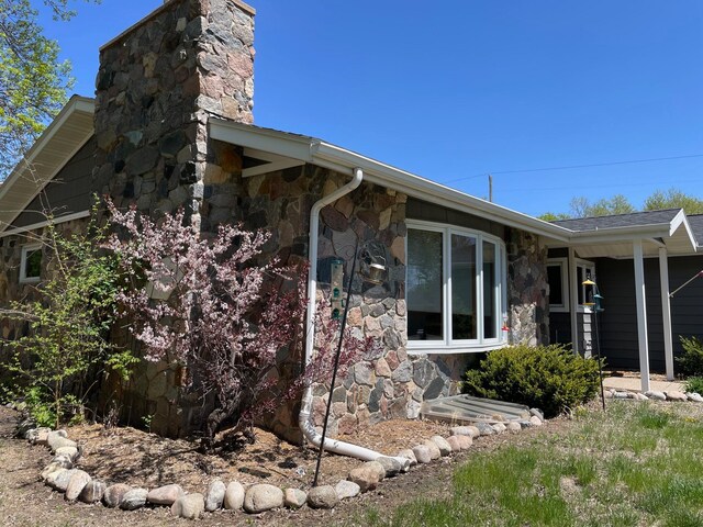 675 10th St, Granite Falls, MN 56241 - view of side of property with stone siding and a chimney