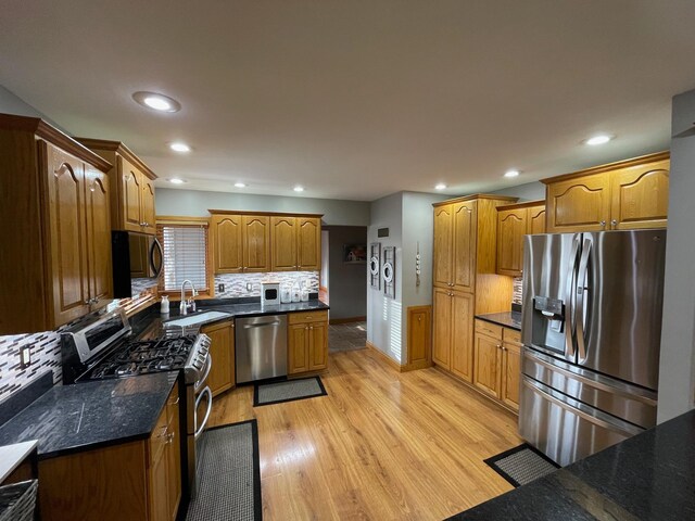 675 10th St, Granite Falls, MN 56241 - kitchen with appliances with stainless steel finishes, light wood finished floors, backsplash, recessed lighting, and brown cabinetry
