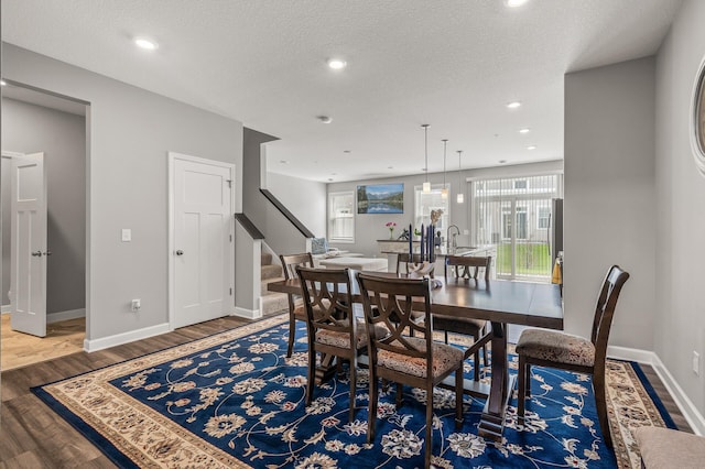 dining area with sink, a textured ceiling, and hardwood / wood-style floors