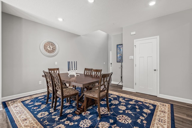 dining room with wood-type flooring and a textured ceiling