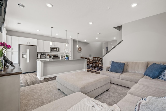 living room with sink and light wood-type flooring