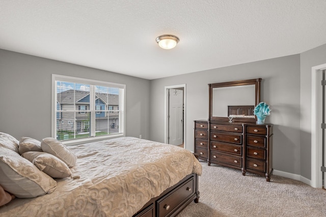 bedroom featuring light carpet and a textured ceiling