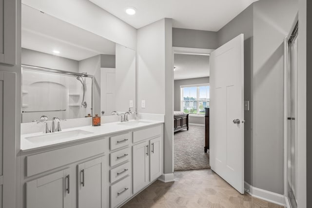 bathroom featuring walk in shower and dual bowl vanity