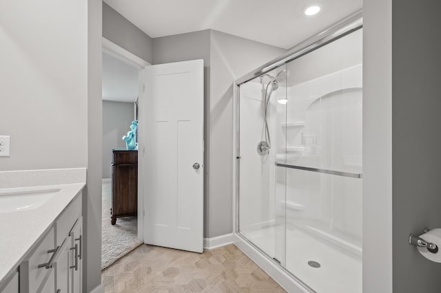 bathroom featuring a shower with door, vanity, and parquet floors