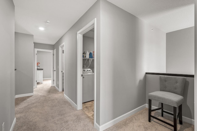 hallway with light carpet and washer / clothes dryer