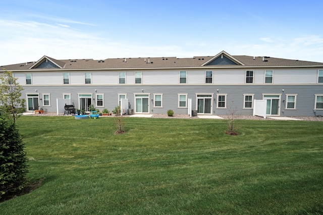 rear view of house featuring a patio and a lawn