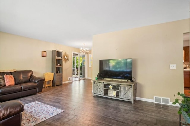 living room with a notable chandelier and dark wood-type flooring