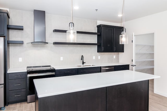 kitchen with a kitchen island, light hardwood / wood-style flooring, stainless steel appliances, sink, and wall chimney range hood