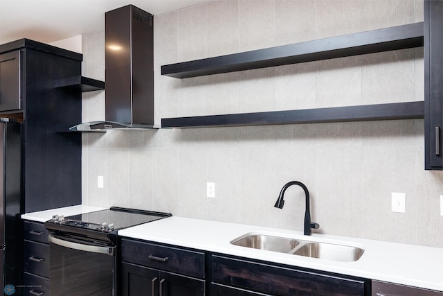 kitchen with stainless steel electric range oven, sink, decorative backsplash, wall chimney exhaust hood, and black fridge