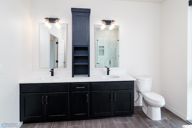 bathroom featuring a shower with shower door, toilet, hardwood / wood-style flooring, and vanity