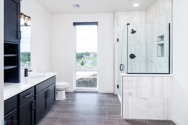 bathroom featuring vanity, toilet, hardwood / wood-style floors, and a shower with shower door