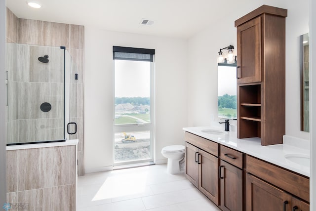 bathroom with tile patterned flooring, vanity, toilet, and walk in shower