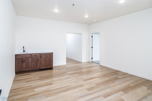 unfurnished room with light wood-type flooring and sink